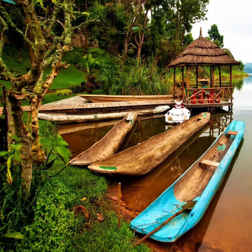 Traditional wooden boats moored at lakeside dock with gazebo