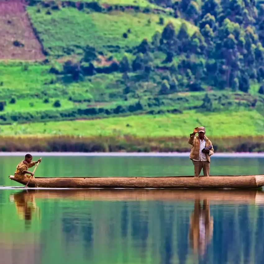 Two people fishing from wooden boat on calm lake