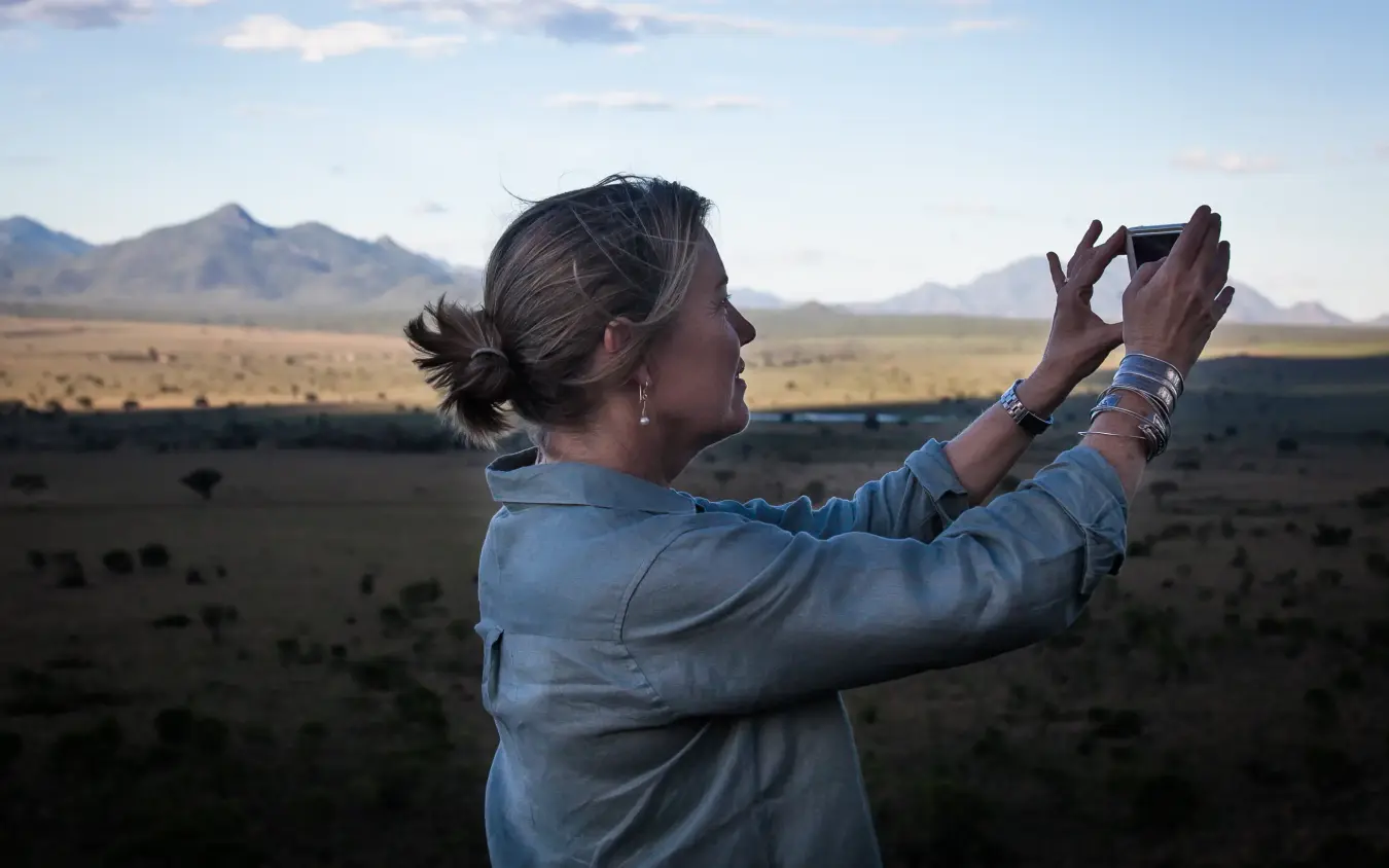 Guest photographing wildlife in vast savanna landscape, Apoka Safari Lodge, Kidepo Valley, Uganda