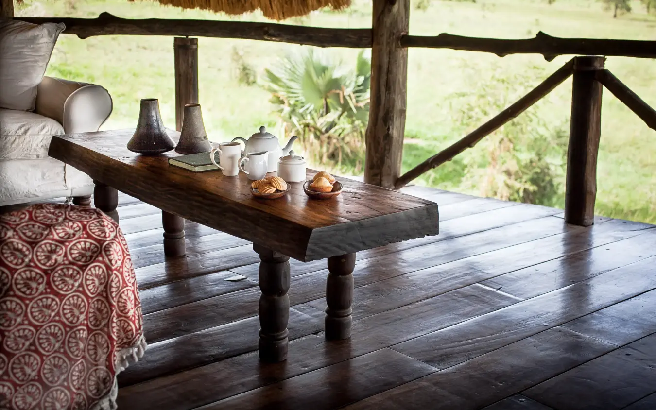 Wooden deck with tea service overlooking savanna landscape, Apoka Safari Lodge, Kidepo Valley, Uganda