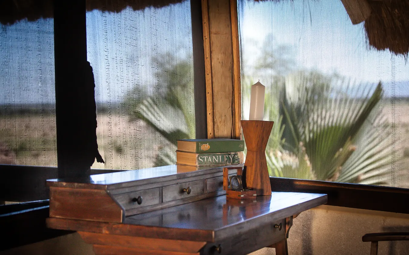 Wooden desk with view of savanna landscape through windows, Apoka Safari Lodge, Kidepo Valley, Uganda