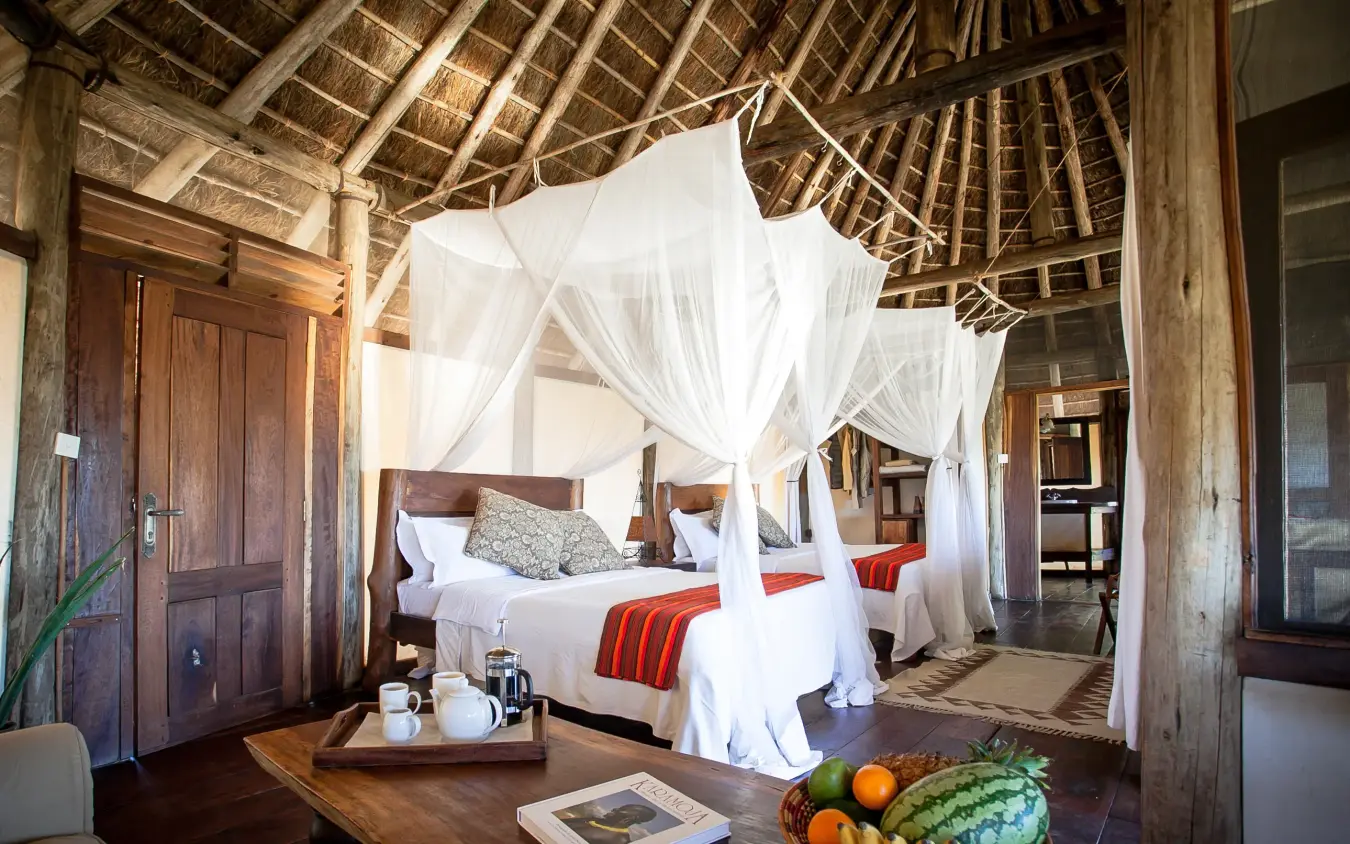 Spacious bedroom with four-poster canopy bed and thatched ceiling, Apoka Safari Lodge, Kidepo Valley, Uganda
