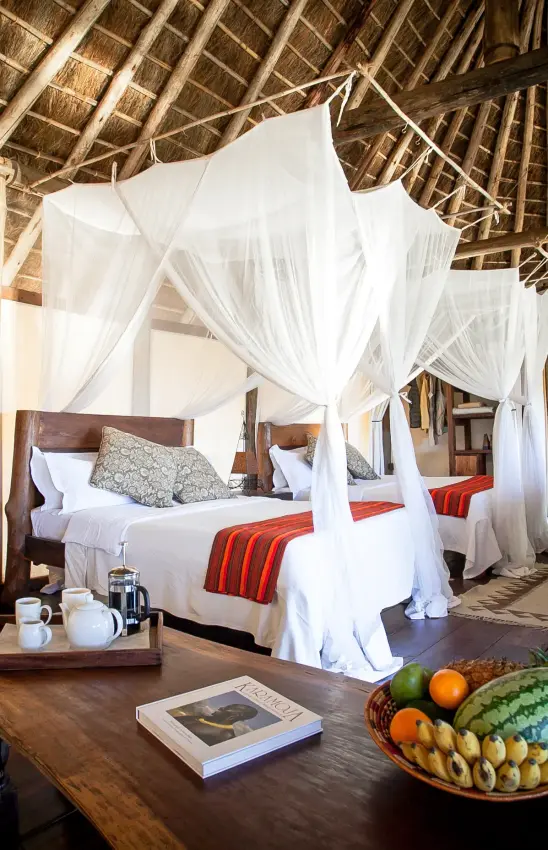 Spacious bedroom with four-poster canopy bed and thatched ceiling, Apoka Safari Lodge, Kidepo Valley, Uganda