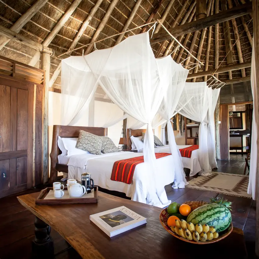 Spacious bedroom with four-poster canopy bed and thatched ceiling, Apoka Safari Lodge, Kidepo Valley, Uganda