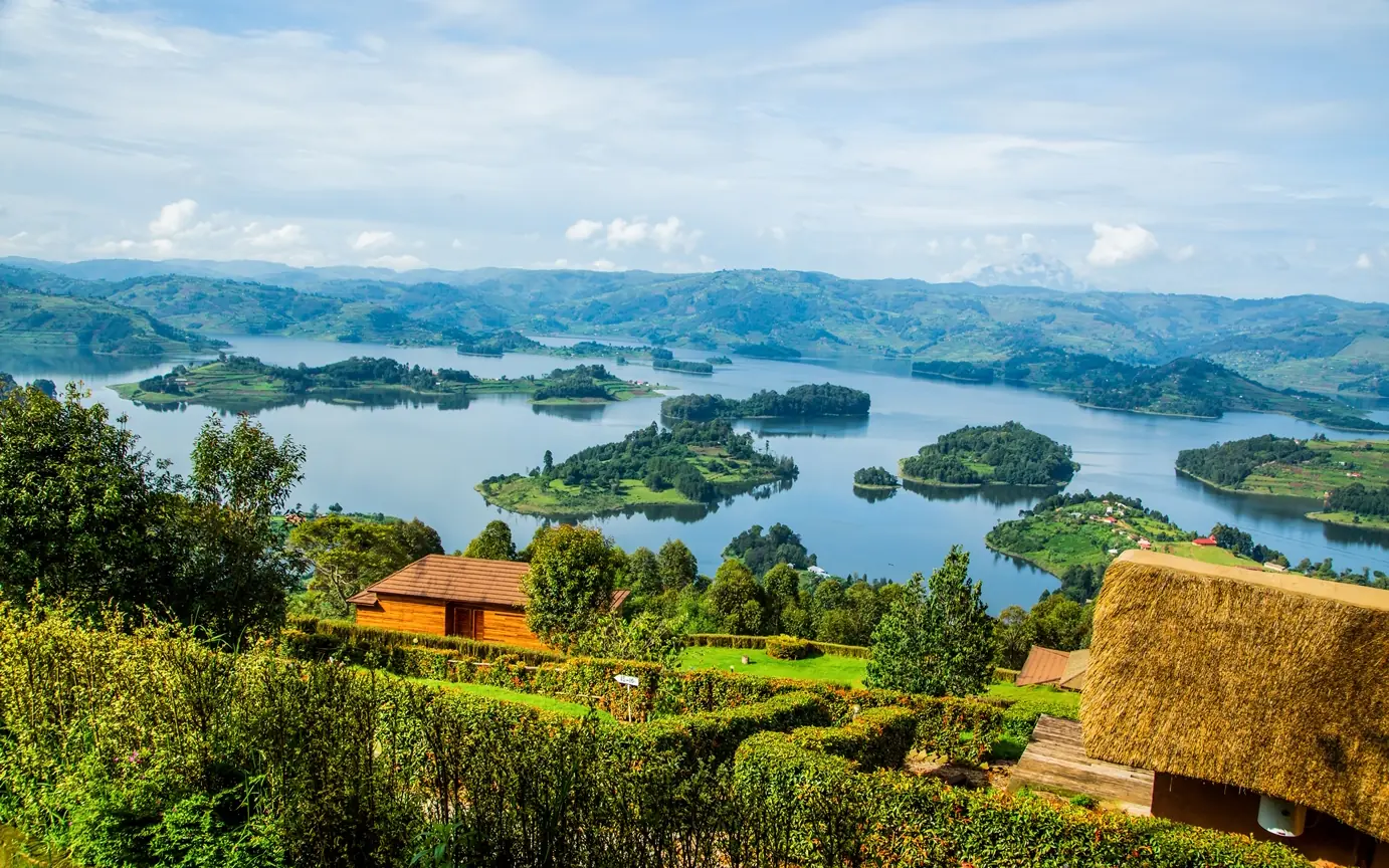 Scenic lake landscape with islands, green hills and traditional buildings, Uganda