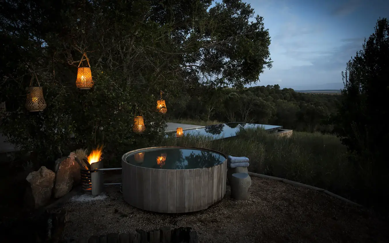 Hot tub overlooking river at dusk with hanging lanterns, Arijiju, Laikipia Highlands, Kenya