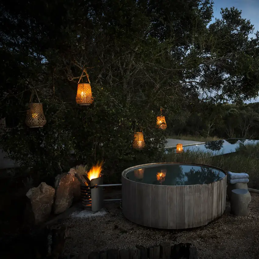 Hot tub overlooking river at dusk with hanging lanterns, Arijiju, Laikipia Highlands, Kenya