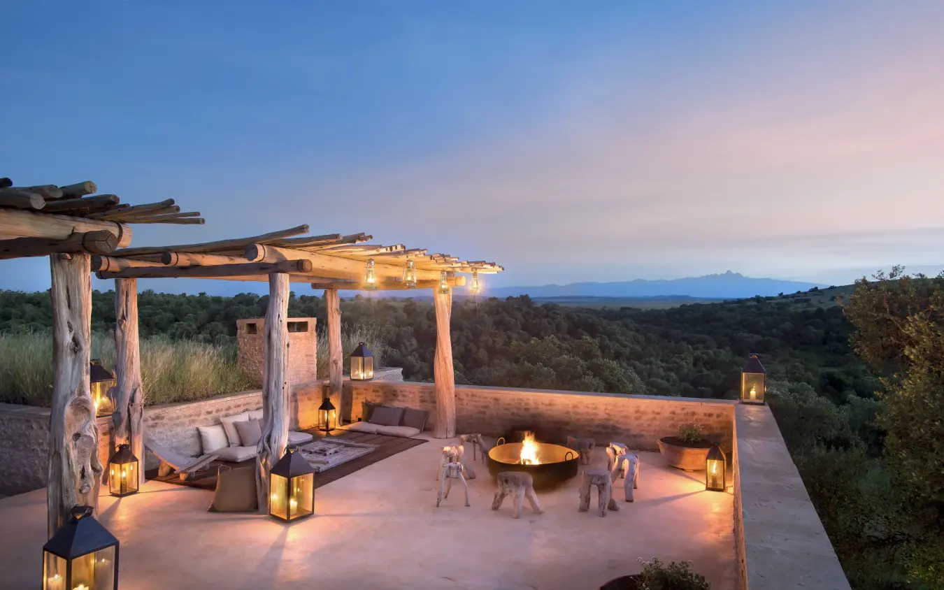 Illuminated outdoor terrace overlooking forested valley at dusk, Arijiju, Laikipia Highlands, Kenya