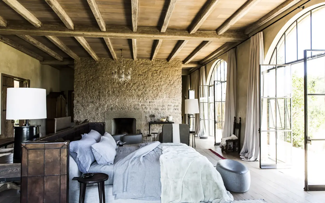 Spacious bedroom with exposed beam ceiling and stone fireplace, Arijiju, Laikipia Highlands, Kenya