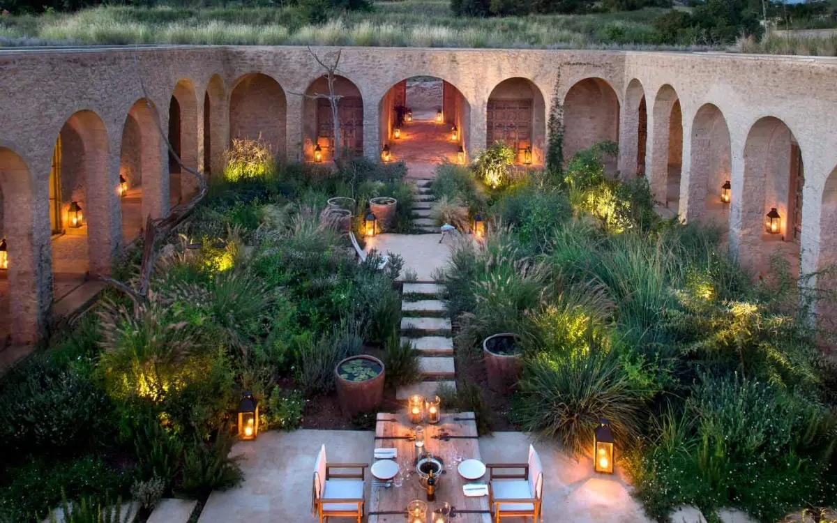 Courtyard dining area with arched colonnade and ambient lighting, Arijiju, Laikipia Highlands, Kenya