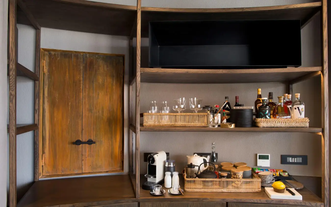Open wooden cabinet displaying beverages and coffee equipment, Sossusvlei Desert Lodge, NamibRand Private Reserve, Namibia