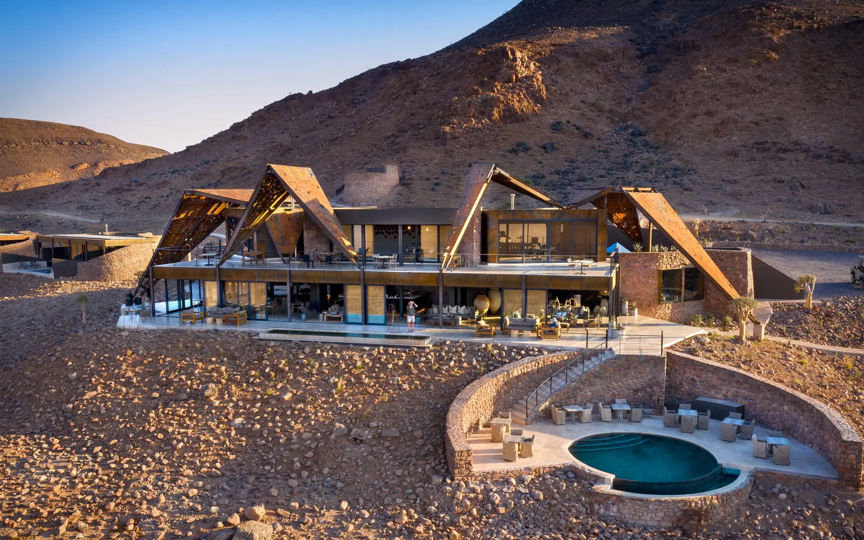 Desert lodge with distinctive peaked roofs and infinity pool, Sossusvlei Desert Lodge, NamibRand Private Reserve, Namibia