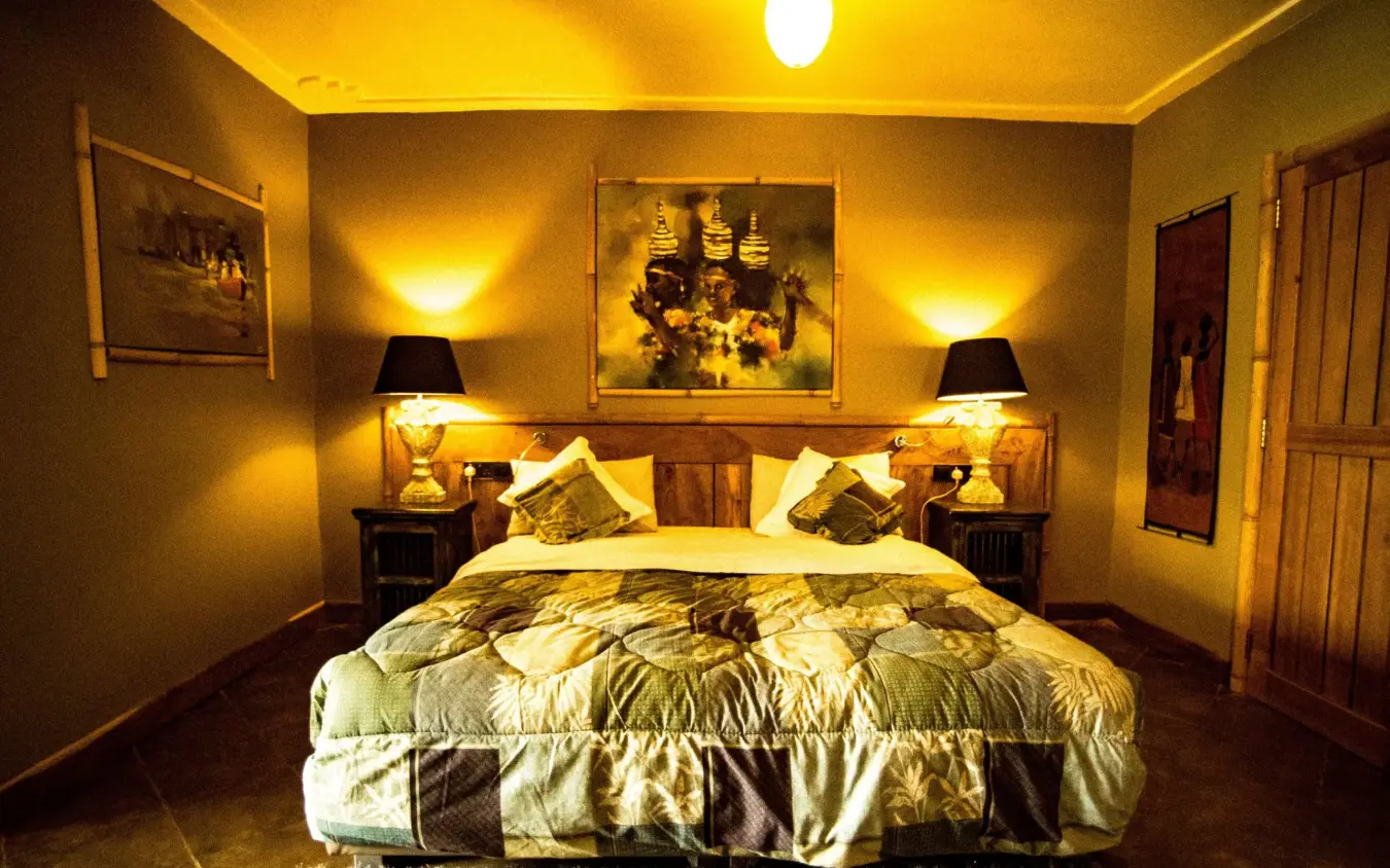 Bedroom with golden walls, patterned bedding, and twin lamps, Birdnest at Bunyonyi Resort, Lake Bunyonyi, Uganda