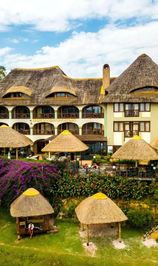 Thatched-roof lodge with cone structures and manicured gardens