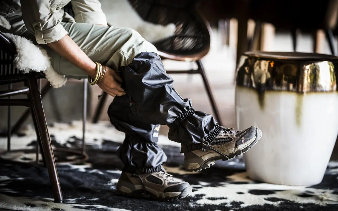 Person putting on hiking boots in lodge interior, Bisate Lodge, Volcanoes National Park, Rwanda
