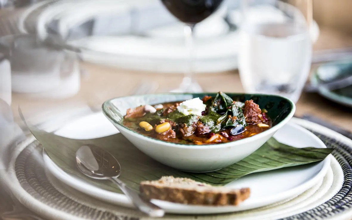Plated soup dish with greens and white cheese garnish, Bisate Lodge, Volcanoes National Park, Rwanda