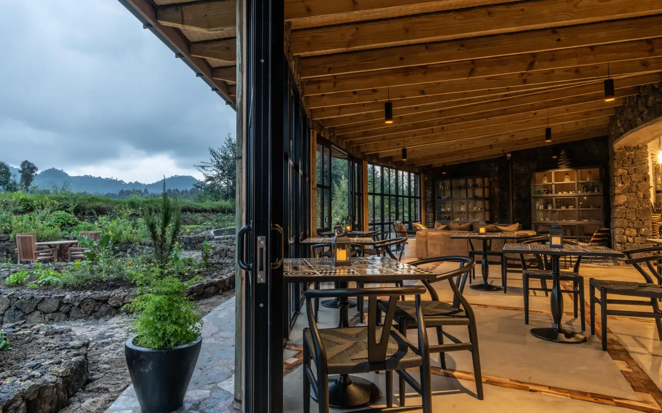 Open-air dining pavilion overlooking agricultural fields and mountains, Bisate Lodge, Volcanoes National Park, Rwanda