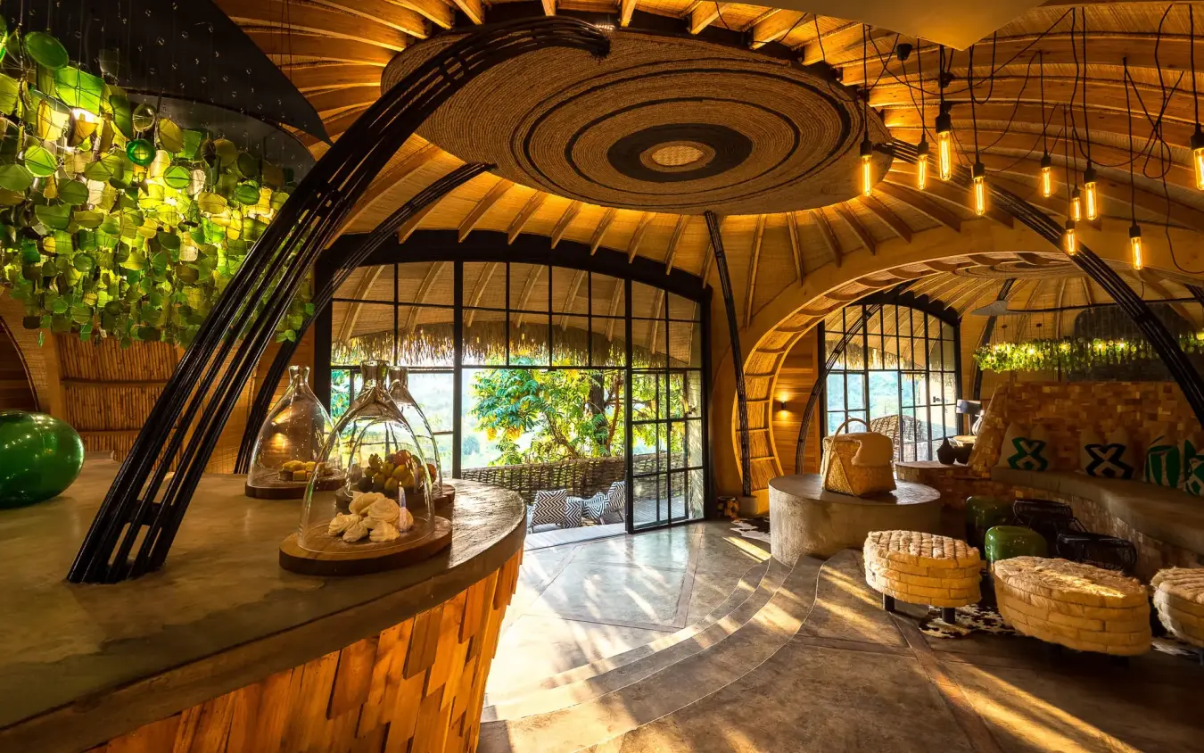 Interior lounge with curved wooden architecture and natural light, Bisate Lodge, Volcanoes National Park, Rwanda