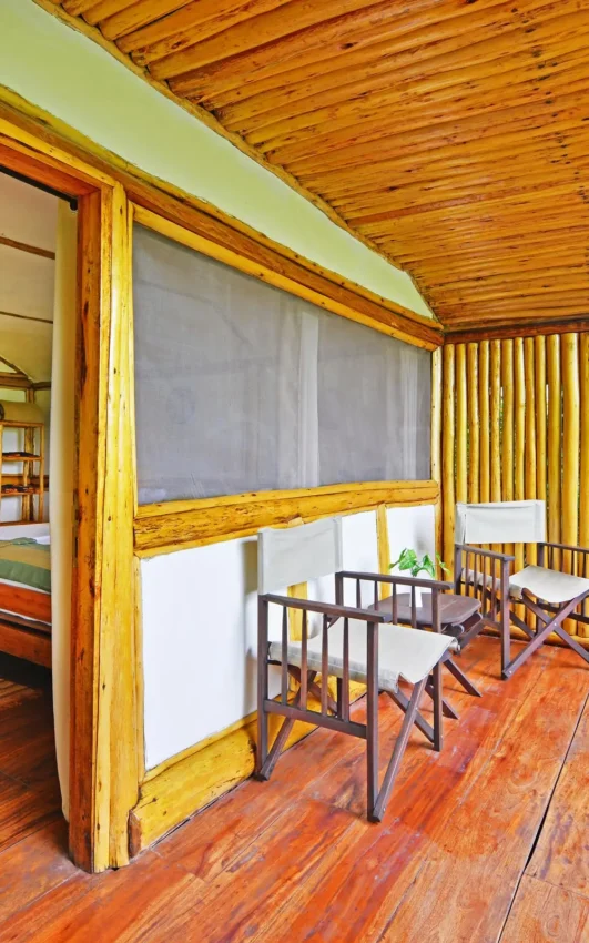 Wooden lodge bedroom with two beds and open deck area, Buhoma Lodge, Bwindi Impenetrable Forest, Uganda
