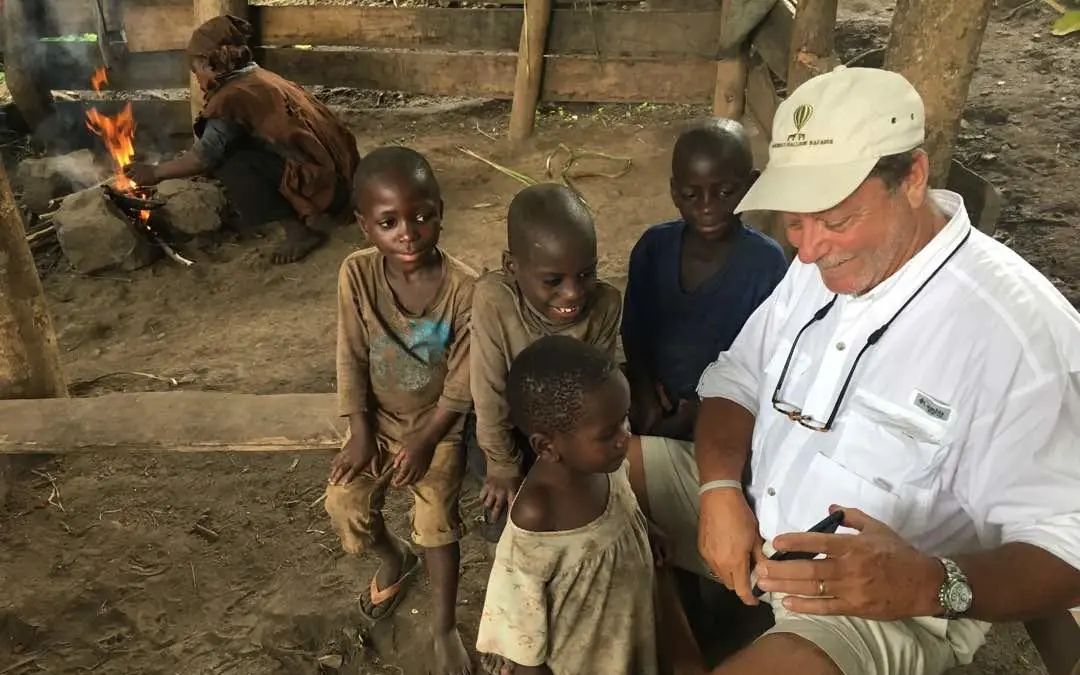 Adult visitor interacting with local children at community site, Buhoma Lodge, Bwindi Impenetrable Forest, Uganda