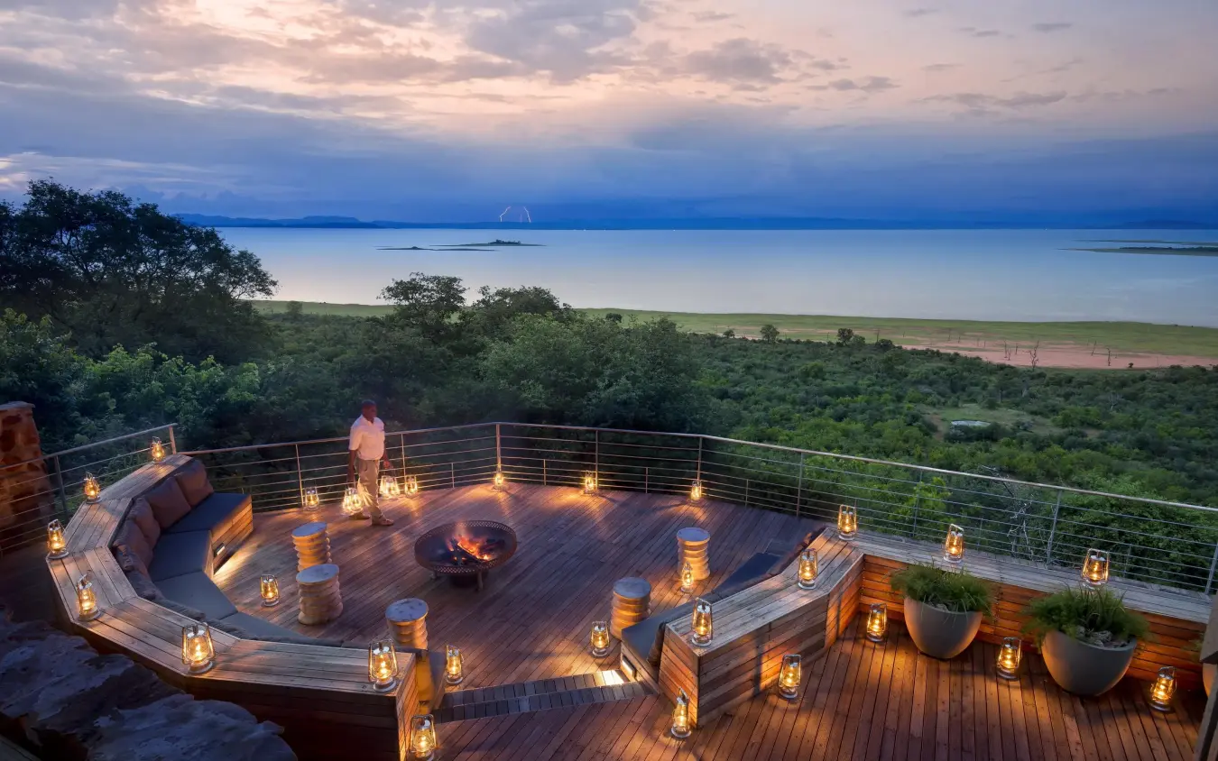 Wooden deck with fire pit overlooking savanna at dusk, Bumi Hills Safari Lodge, Matusadona National Park, Zimbabwe