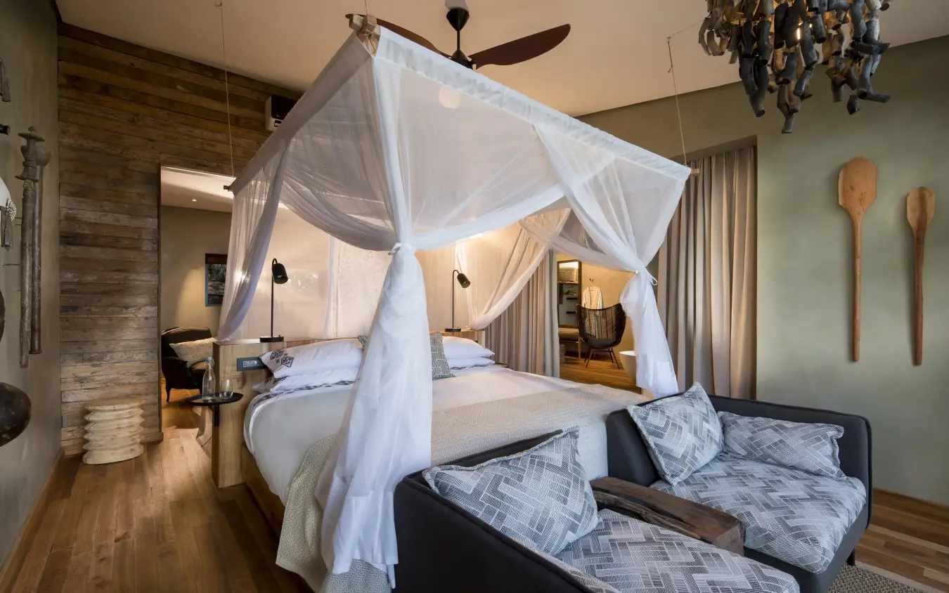 Luxury bedroom with white canopy bed and seating area, Bumi Hills Safari Lodge, Matusadona National Park, Zimbabwe