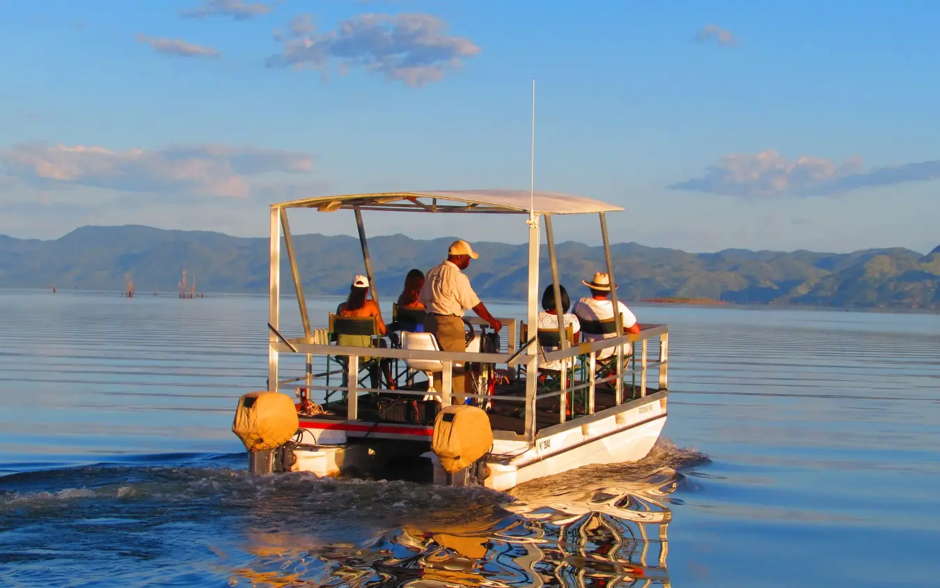 Boat tour with passengers on calm lake water, Changa Safari Camp, Matusadona National Park, Zimbabwe