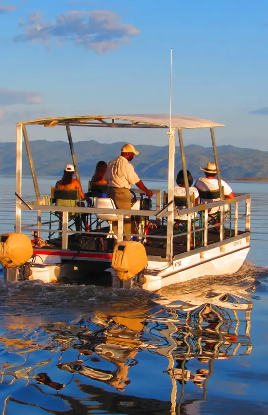 Boat tour with passengers on calm lake water, Matusadona, Zimbabwe