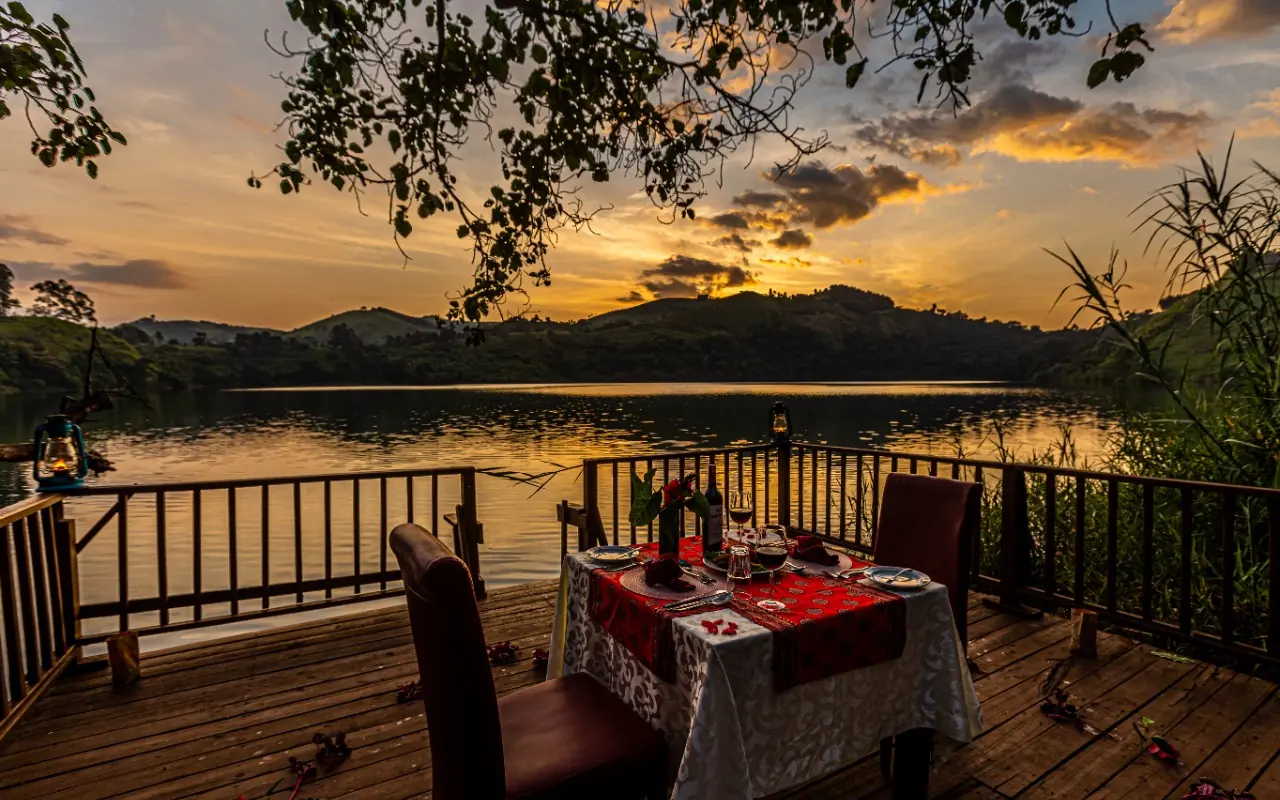 Lakeside dining setup on wooden deck at sunset, Crater Safari Lodge, Kibale Forest, Uganda