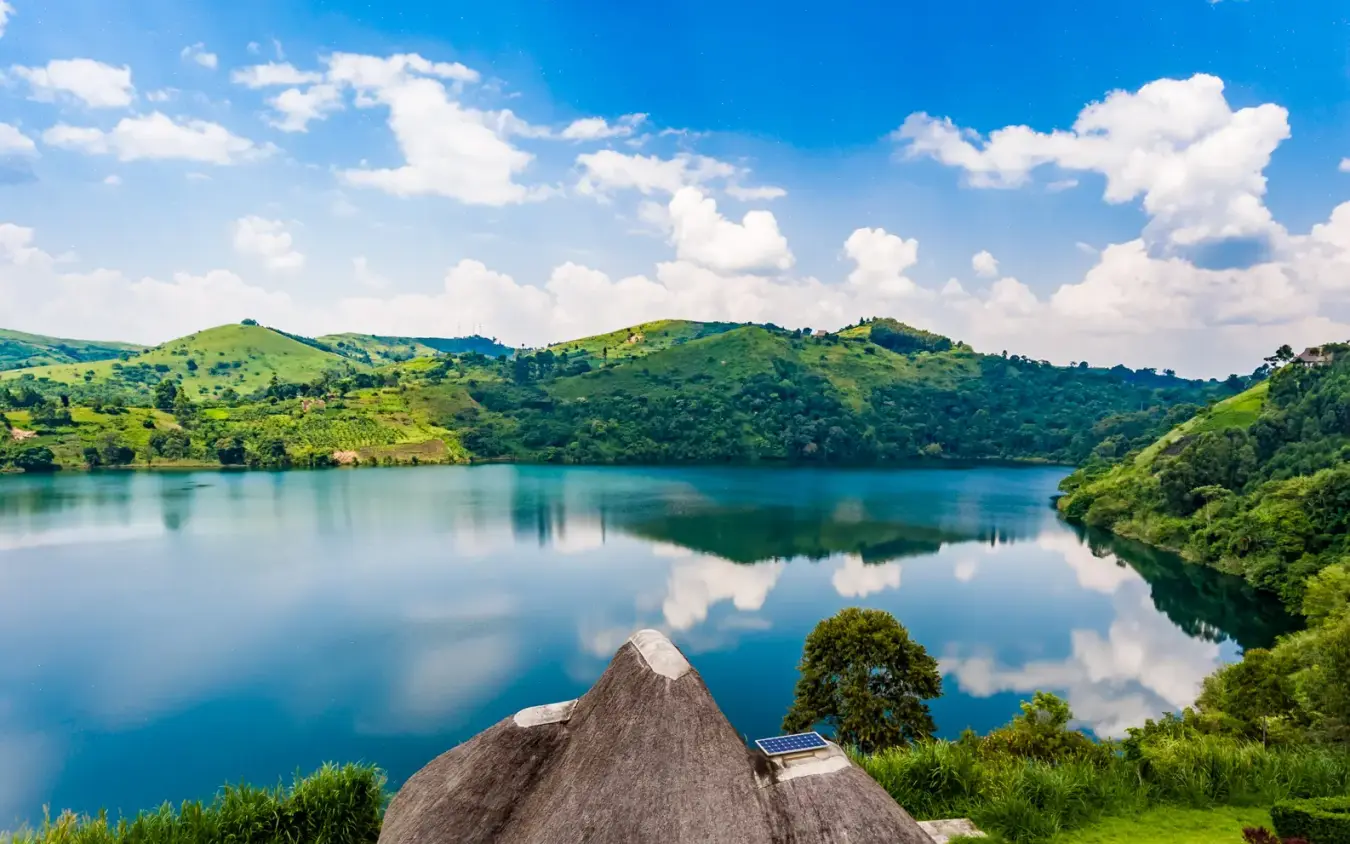 Crater lake with green hills reflected in still water, Crater Safari Lodge, Kibale Forest, Uganda