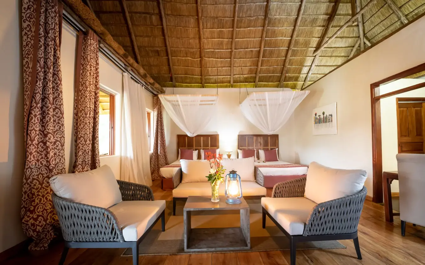 Spacious bedroom suite with sitting area and twin beds, Crater Safari Lodge, Kibale Forest, Uganda