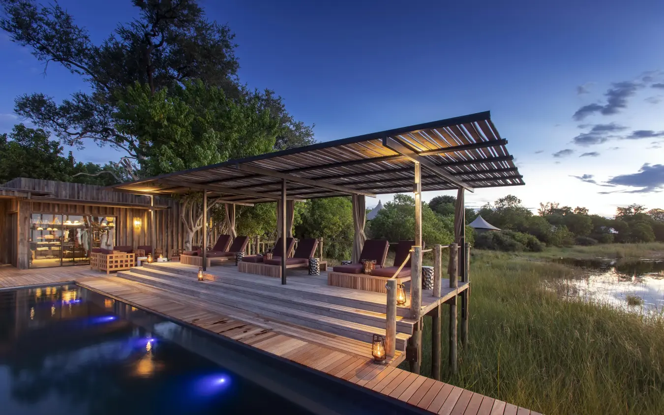 Waterfront deck with pool overlooking wetland at dusk, DumaTau, Linyanti Wildlife Reserve, Botswana