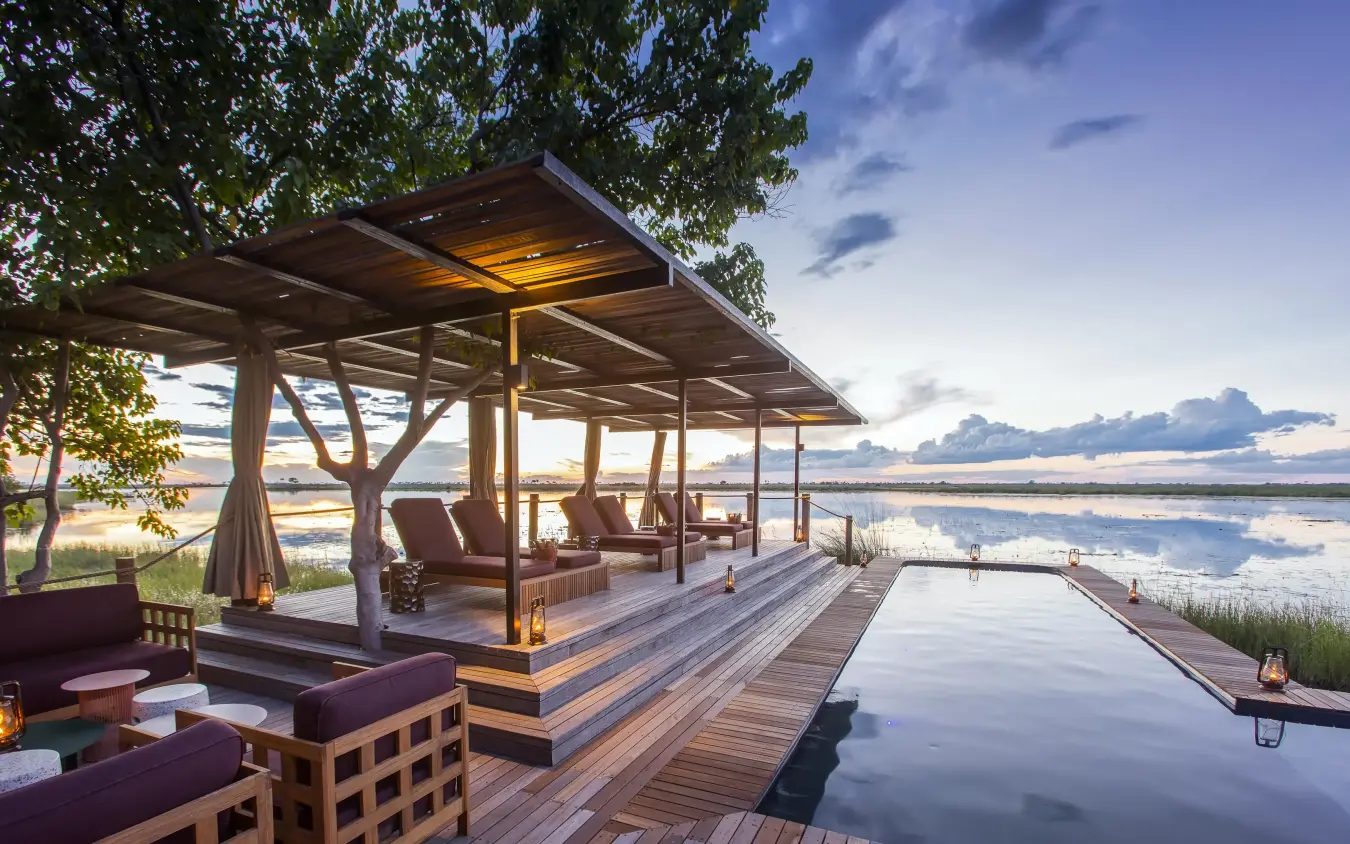 Wooden deck with lounge seating overlooking calm water, DumaTau, Linyanti Wildlife Reserve, Botswana