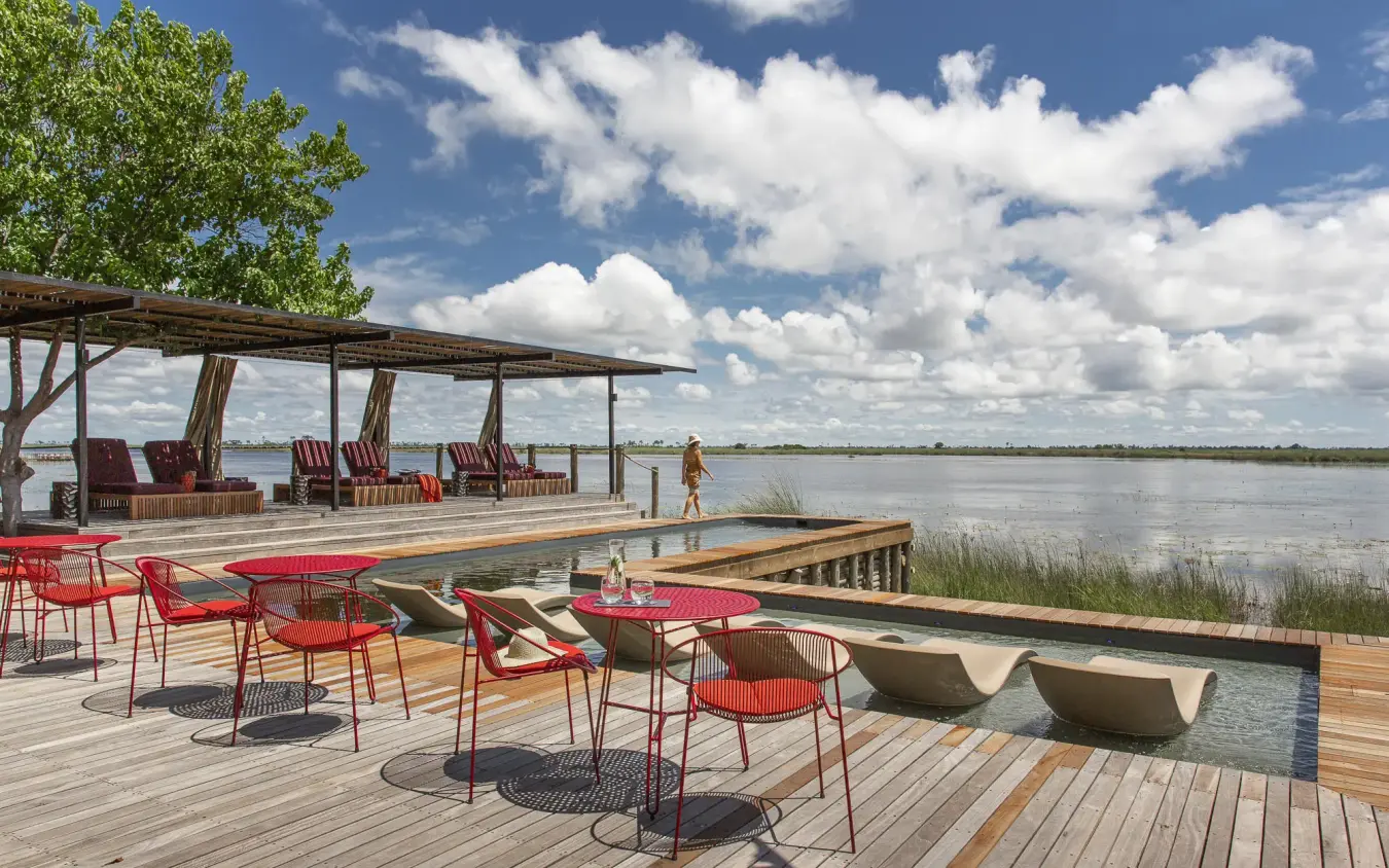 Waterfront deck with red seating overlooking vast lagoon, DumaTau, Linyanti Wildlife Reserve, Botswana