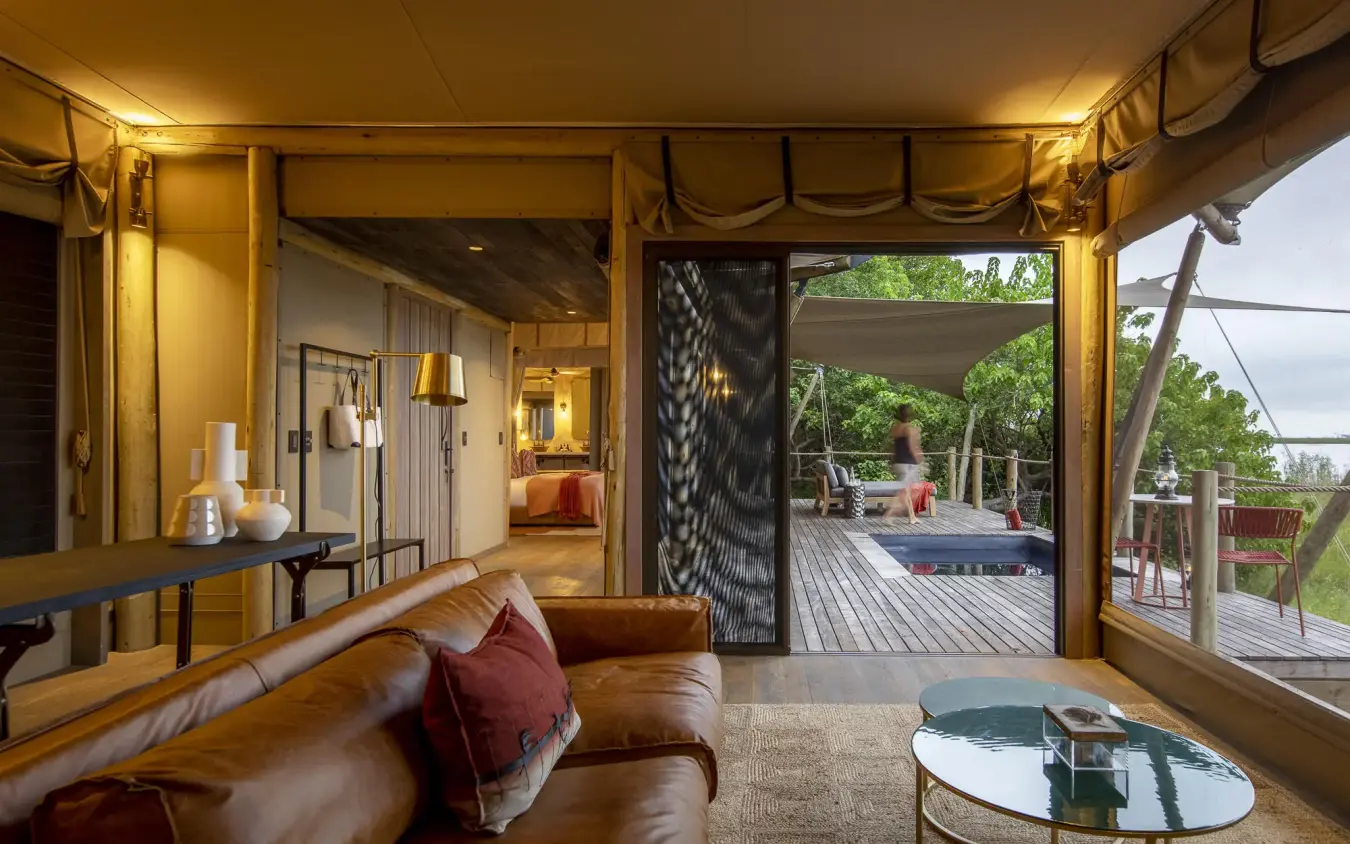 Luxury tent interior with leather seating and deck views, DumaTau, Linyanti Wildlife Reserve, Botswana