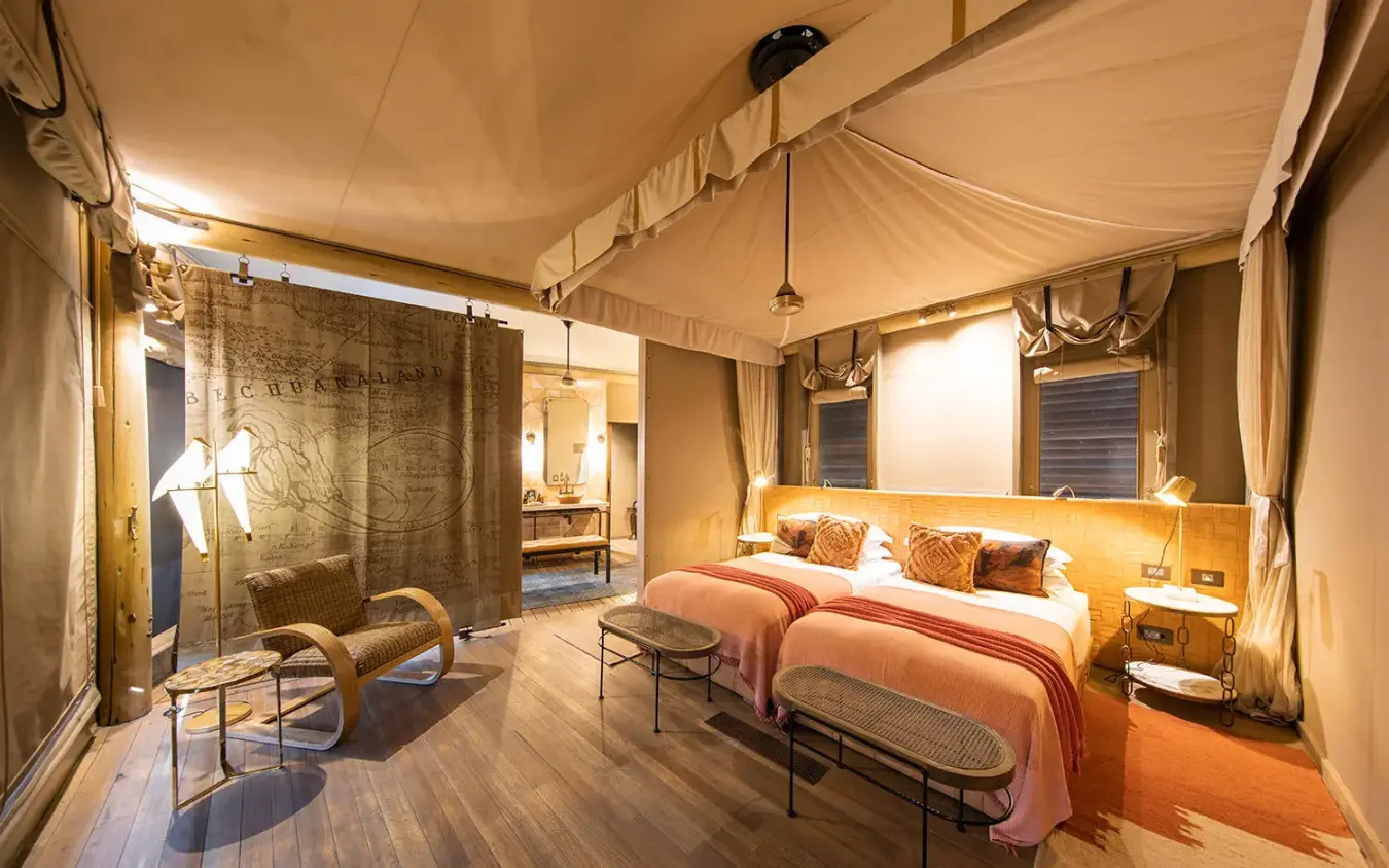 Luxury bedroom with draped canopy and lounge seating area, DumaTau, Linyanti Wildlife Reserve, Botswana