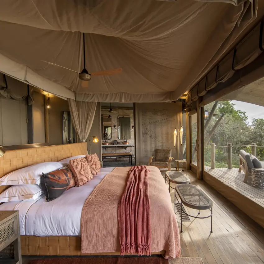 Luxury safari bedroom with bed overlooking deck and landscape, DumaTau, Linyanti Wildlife Reserve, Botswana