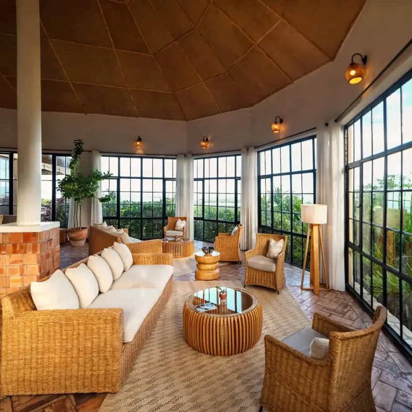 Circular lounge with wicker furniture and panoramic windows, Elephant Plains Lodge, Queen Elizabeth NP, Uganda