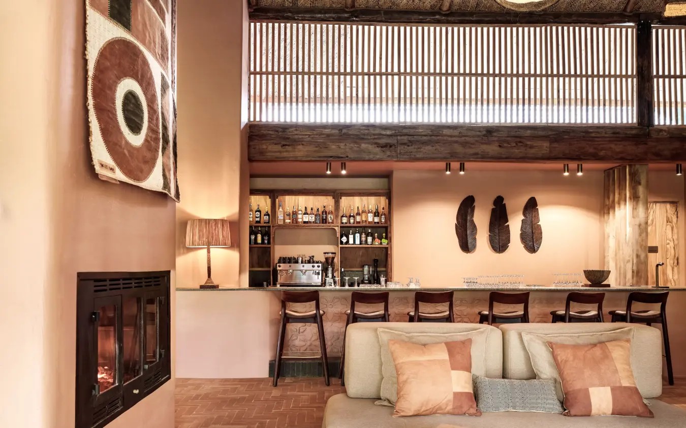 Modern lounge with fireplace, bar seating, and earth tones, Gorilla Forest Lodge, Bwindi Impenetrable Forest, Uganda