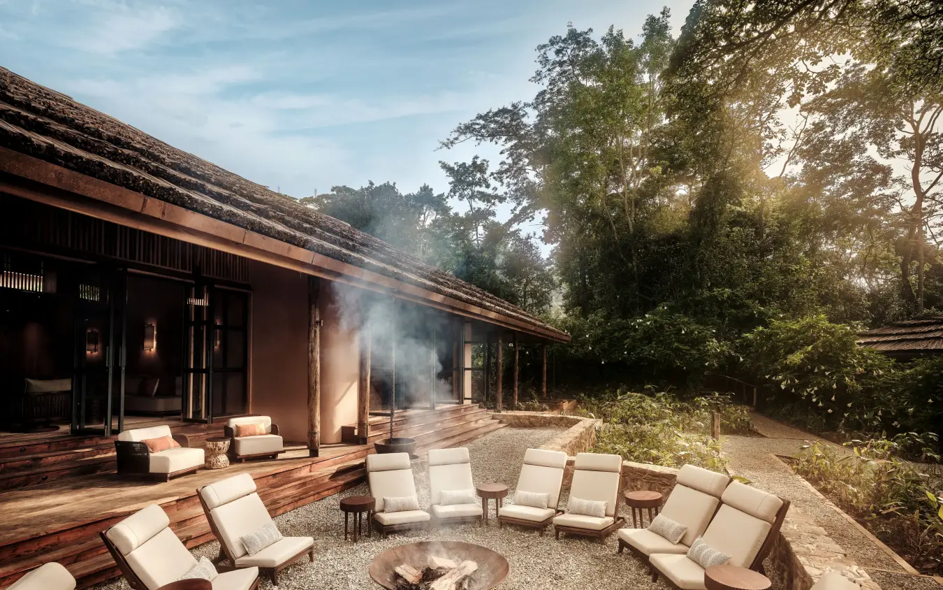 Fire pit seating area with cream chairs and forest backdrop, Gorilla Forest Lodge, Bwindi Impenetrable Forest, Uganda