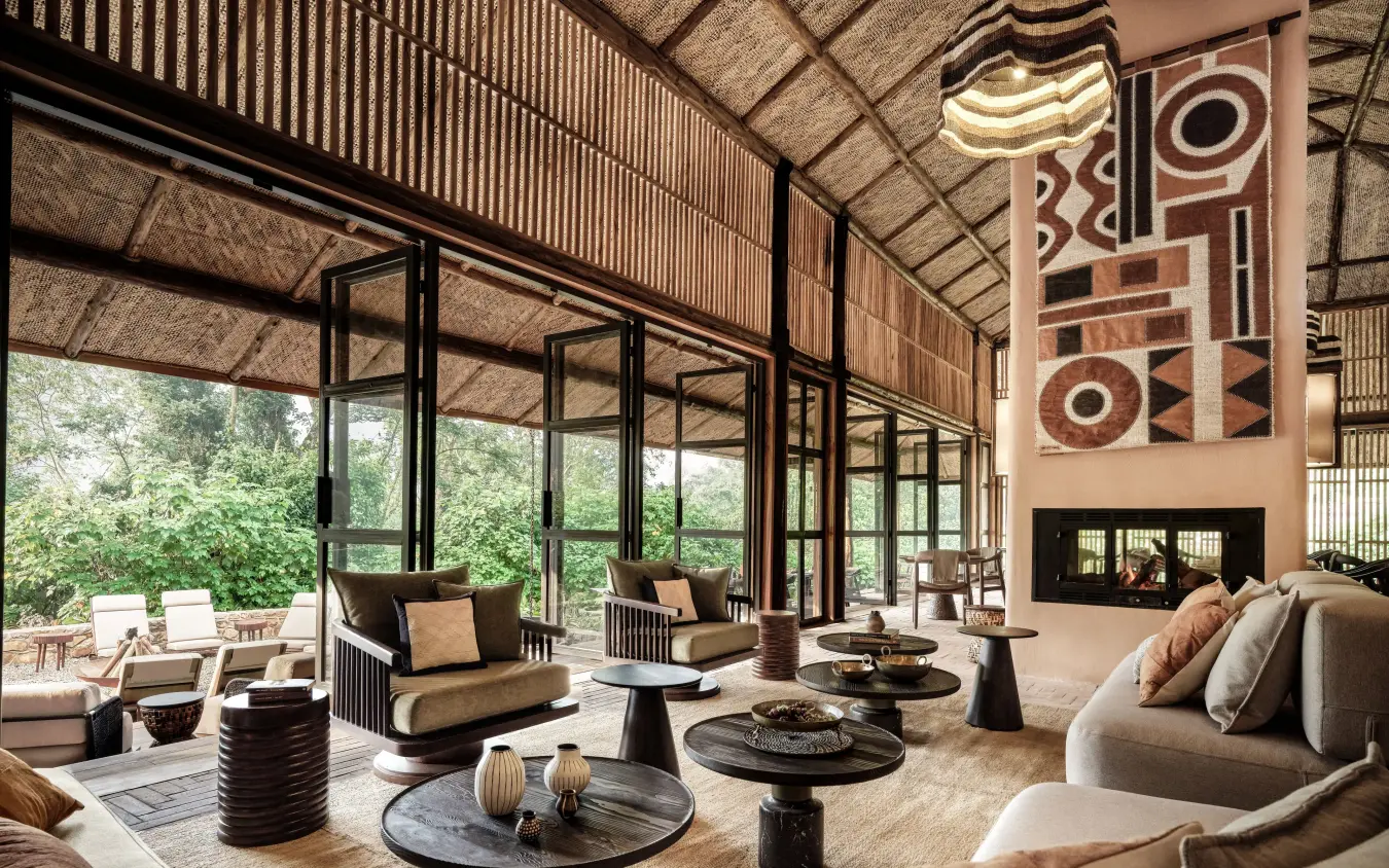 Spacious lounge with curved seating and large windows overlooking forest, Gorilla Forest Lodge, Bwindi Impenetrable Forest, Uganda
