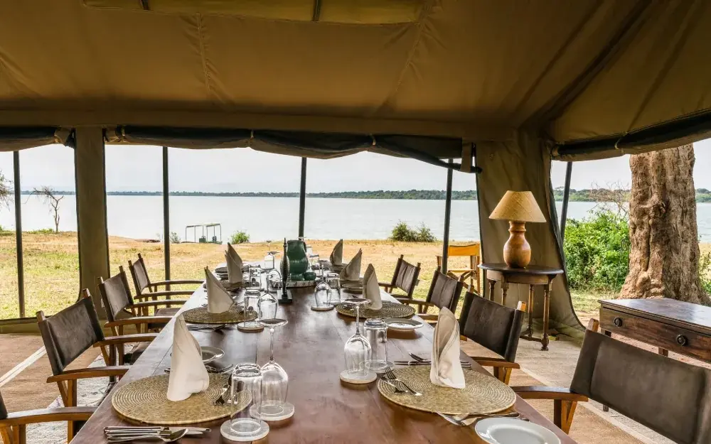 Dining pavilion overlooking lake with place settings, Honey Bear Bush Camp, Queen Elizabeth NP, Uganda