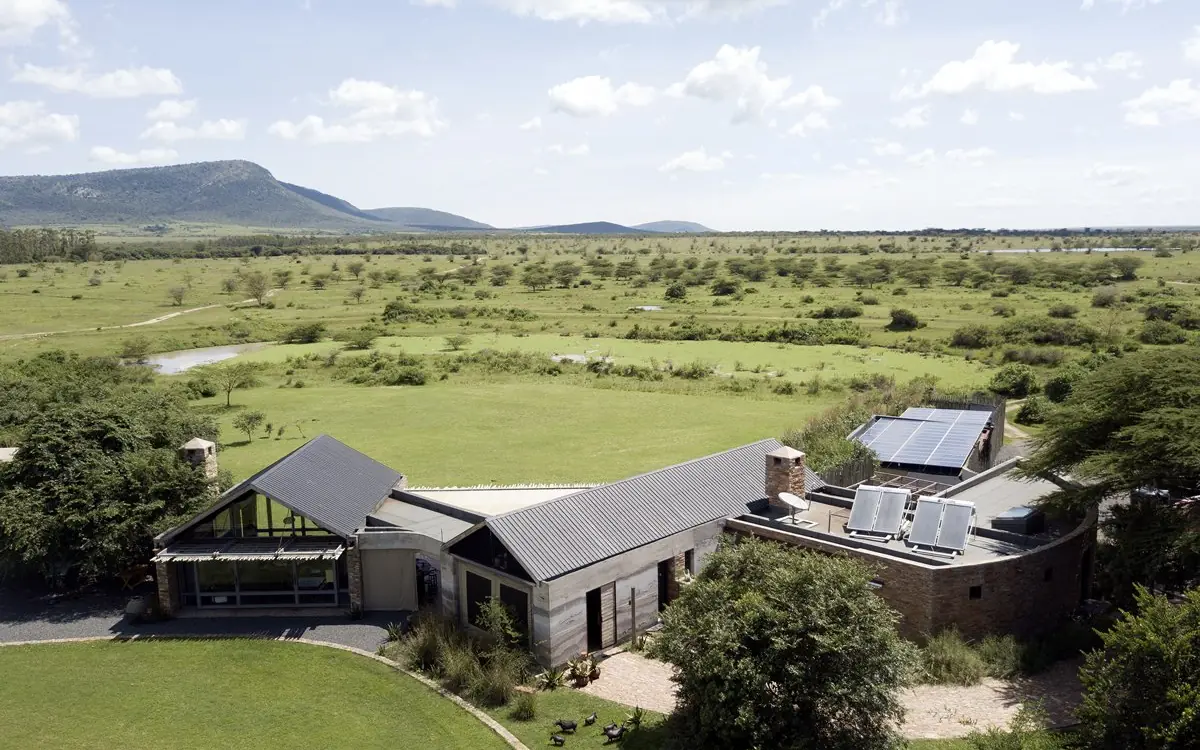 Modern lodge building with solar panels overlooking savanna landscape, House In The Wild, Maasai Mara, Kenya