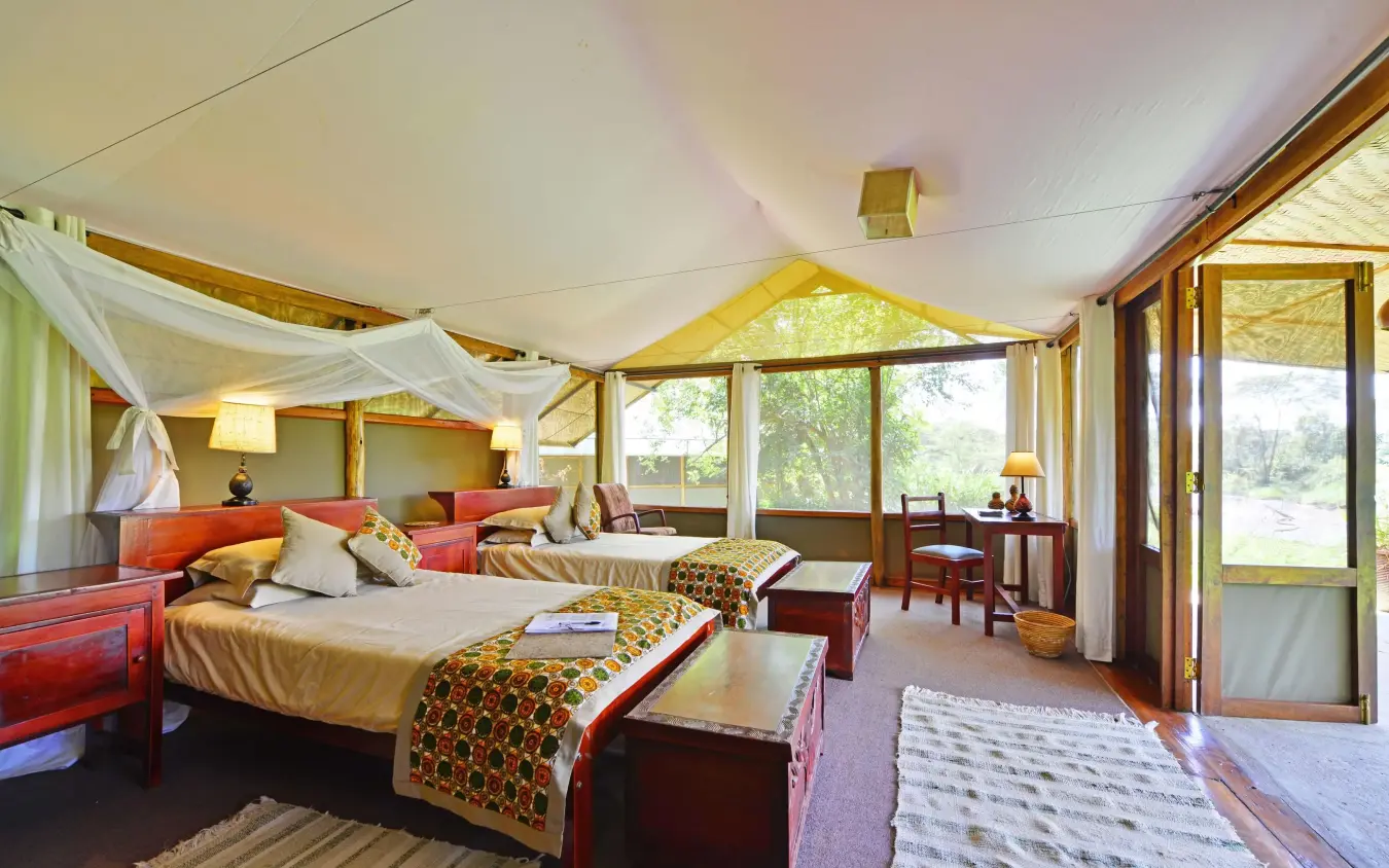 Spacious safari bedroom with twin beds and large windows, Ishasha Wilderness Camp, Queen Elizabeth NP, Uganda