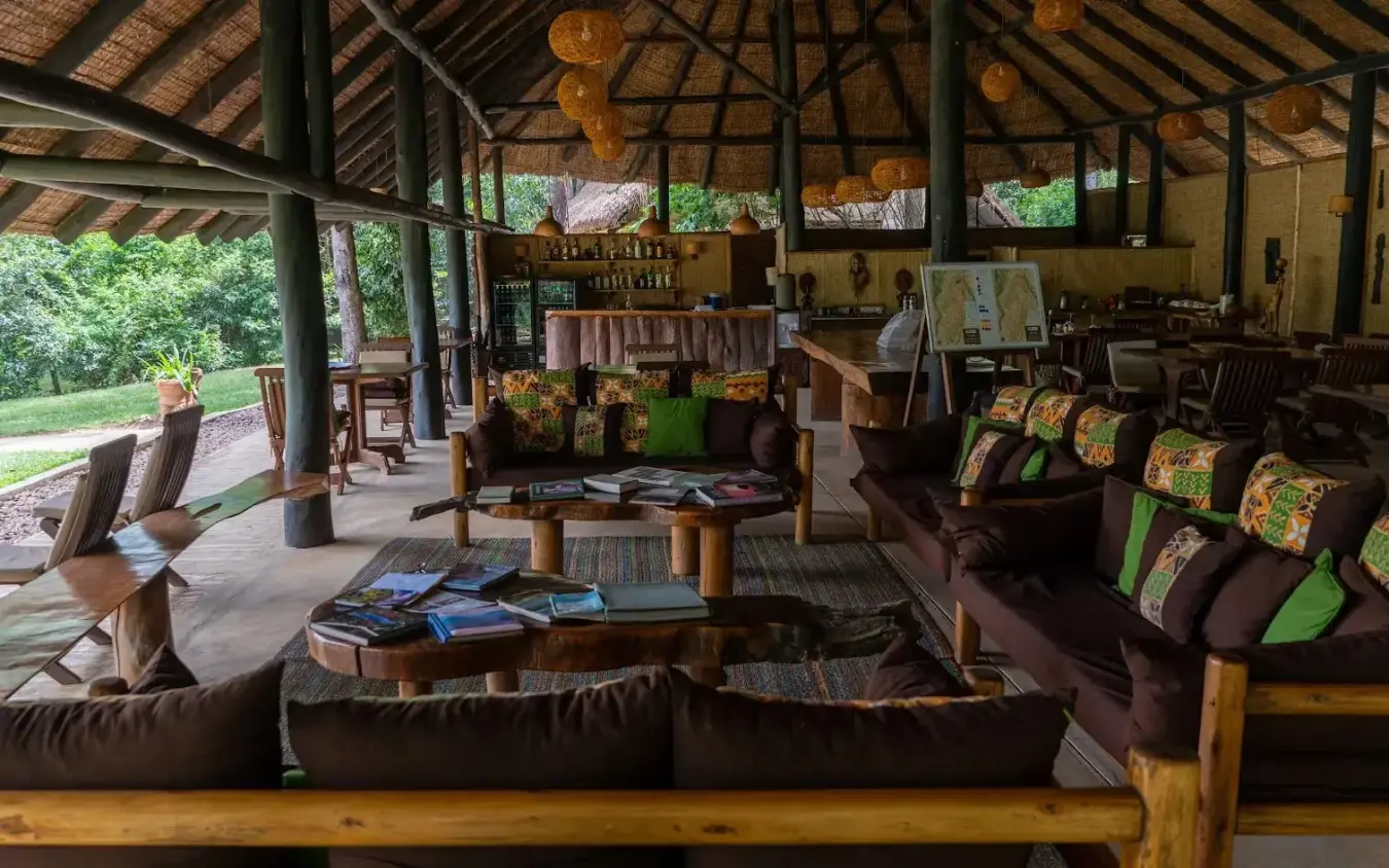 Open-air lounge pavilion with wooden beams and seating, Ishasha Wilderness Camp, Queen Elizabeth NP, Uganda
