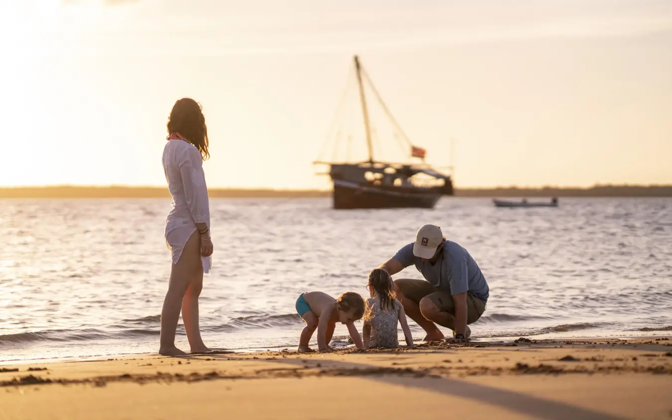 Family wading in shallow water at sunset beach, Tusitiri Dhow, Lamu Archipelago, Kenya