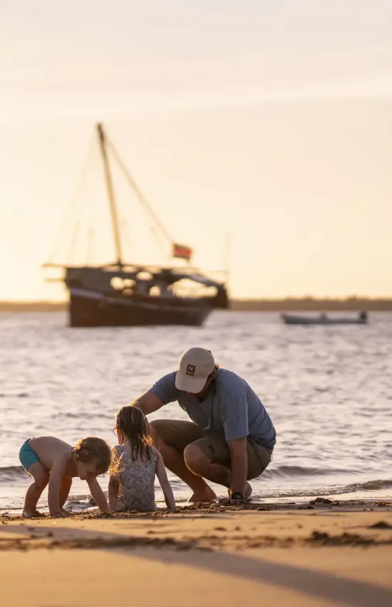 Family wading in shallow water at sunset beach, Tusitiri Dhow, Lamu Archipelago, Kenya