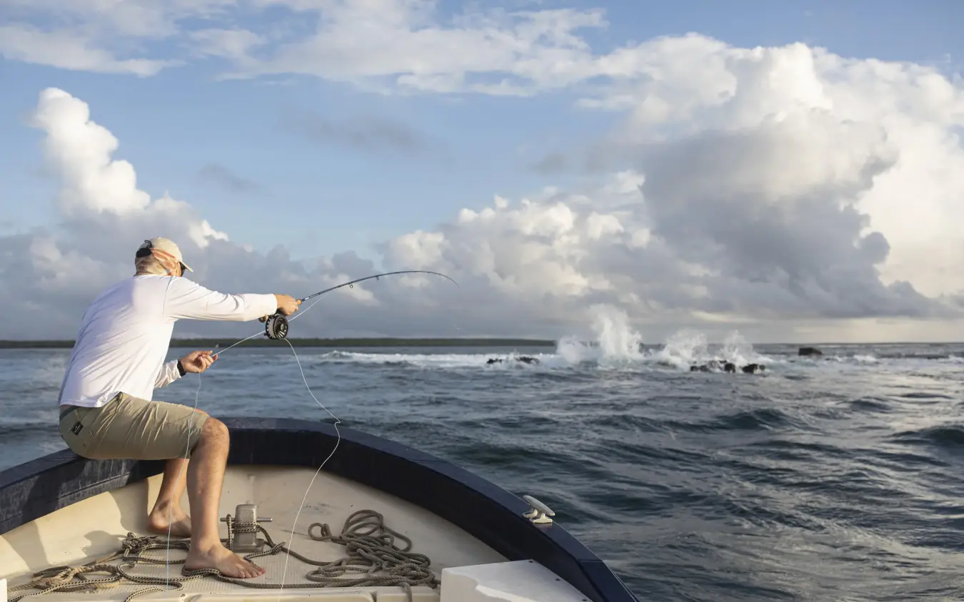 Fisherman casting line from boat into ocean waves, Tusitiri Dhow, Lamu Archipelago, Kenya