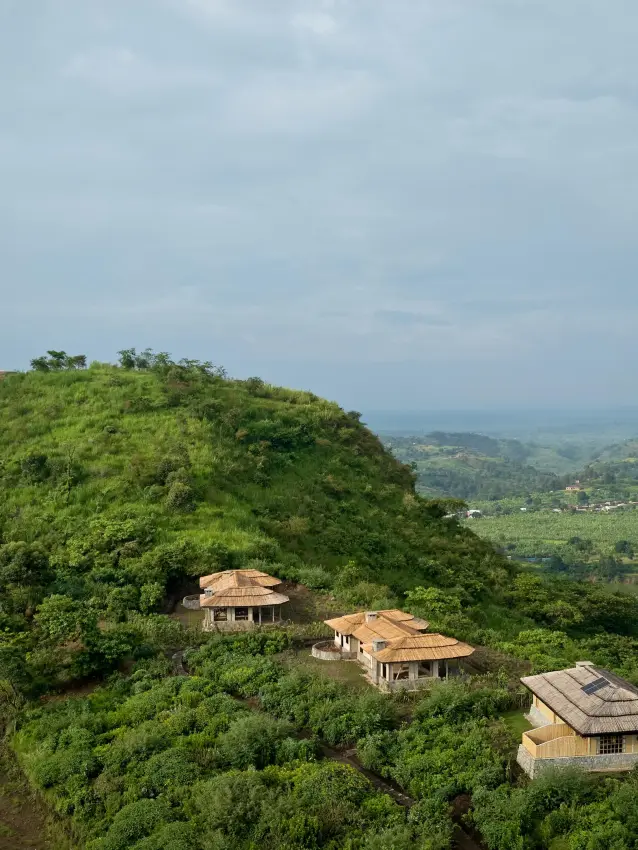 Lodge buildings nestled on hilltop surrounded by lush forest, Kibale Forest, Uganda