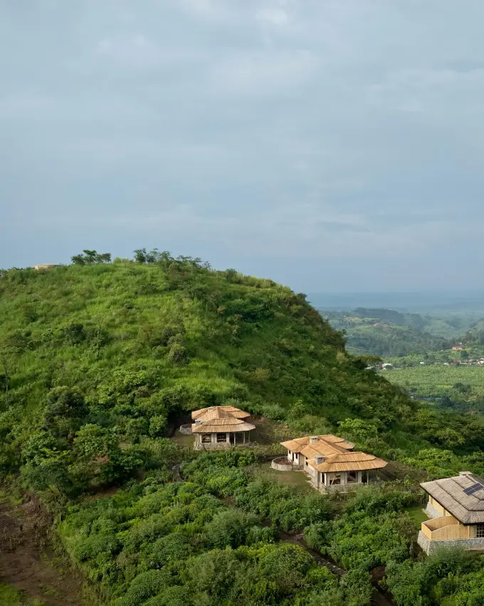 Lodge buildings nestled on hilltop surrounded by lush forest, Kibale Lodge, Kibale Forest, Uganda